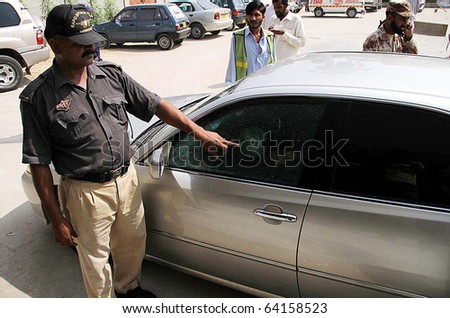 KARACHI, PAKISTAN - OCT 28: Police official points to bullet sign at Japan Consulate vehicle after firing incident, at Jinnah hospital on October 28, 2010 in Karachi.
