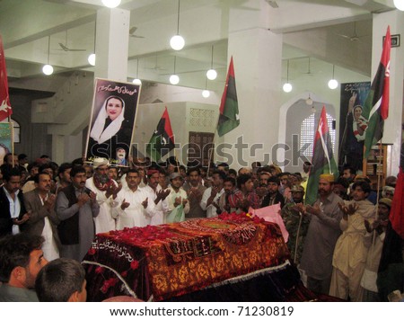 GARHI KHUDA BUX, PAKISTAN - FEB 14: Supporters of Peoples Party (PPP) offer Dua (pray) at the Grave PPP Chairperson, Benazir Bhutto on February 14, 2011, Pakistan