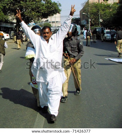 KARACHI, PAKISTAN - FEB 17: Police official arrest protesters during protest rally of members of Sindh Lower Staff Association in favor of their demands on February 17, 2011in Karachi.