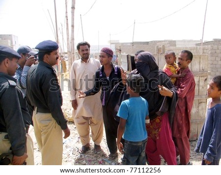KARACHI, PAKISTAN - MAY 12: Residents urge local policemen stop the demolition drive of illegal construction by city district government at Al-Mehran Town in the  Korangi area on May 12, 2011 in Karachi, Pakistan.