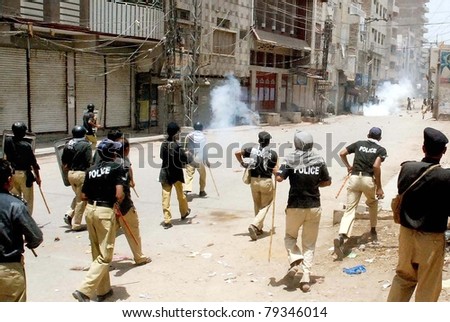 SUKKUR, PAKISTAN - JUN 15: Policemen fire teargas shells to disperse protesters after clash with them during an anti-encroachments drive on June 15, 2011 in Sukkur.