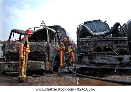 PESHAWAR, PAKISTAN - AUG 07: Firefighters extinguish fire on burning NATO oil-tankers which were caught on fire following a blast last night, on early morning on August 07, 2011in Peshawar.