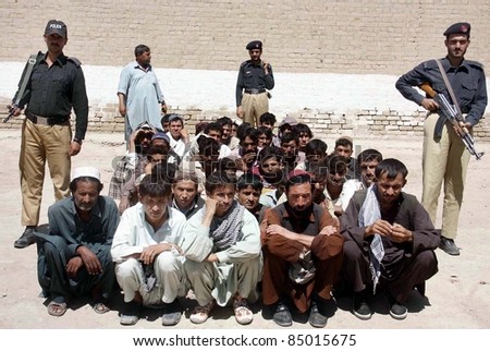 CHAMAN, PAKISTAN - SEPT 19: Policemen escort arrested Afghan nationals who were arrested by Frontier Crops (FC) at Pak-Afghan border during press conference in Chaman on September 19, 2011 Chaman, Pakistan.