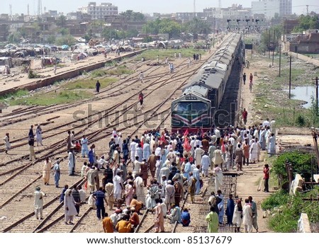 HYDERABAD, PAKISTAN - SEPT 21: Angry protesters stop a passenger train during protest demonstration of employees of railway against non-payment of their salaries on September 21, 2011 Hyderabad.