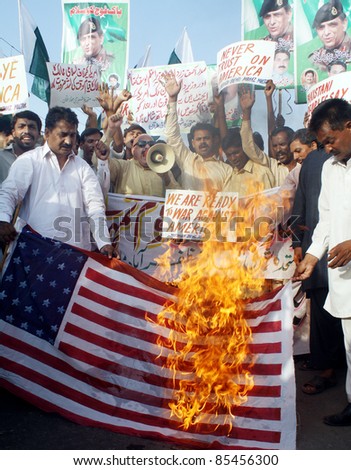 MULTAN, PAKISTAN - SEPT 26: Protesters burn US flag during protest rally organized by Civil Society against US Government on September 26, 2011 in Multan .