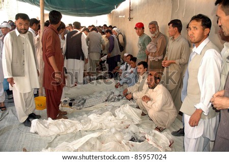 QUETTA, PAKISTAN - OCT 04: People look dead bodies of firing victims who were gunned down in terrorists attack at Akhtarabad area, at mosque on October 04, 2011in Quetta, Pakistan.