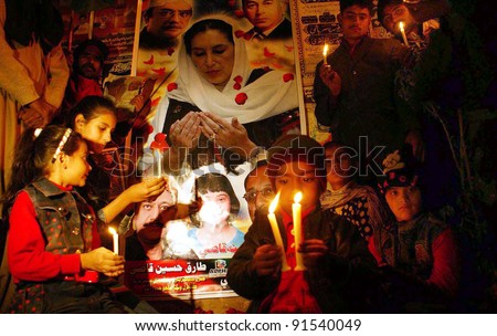 HYDERABAD, PAKISTAN - DEC 26:unidentified Supporters of Peoples Party (PPP) lighten candles during a ceremony to mark the fourth death anniversary of Benazir Bhutto at Hyderabad press club on December 26, 2011.