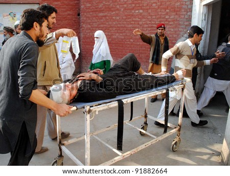 PESHAWAR, PAKISTAN, JAN 03: Volunteers shift an injured man who was injured in explosion, at a hospital in Peshawar on Tuesday, January 03, 2012.