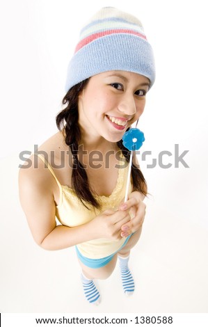 A fun wide-angle shot of a young asian woman in a hat with lollipop