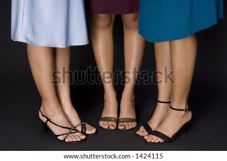 Three pairs of female legs - wearing evening shoes