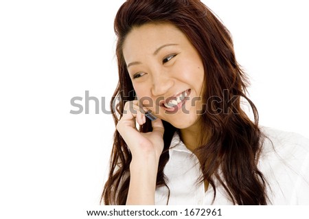 A pretty young asian business woman smiling as she talks on phone