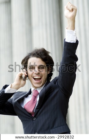 A young man celebrating business success outside