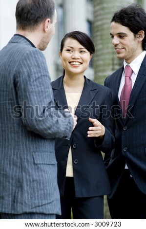 Three business people chatting together outside