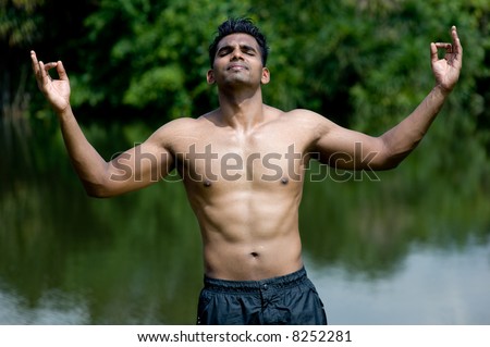 A well-built young man practising yoga outdoors