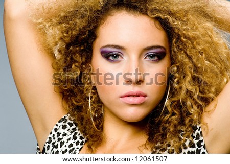A beautiful young woman in animal print dress on grey background
