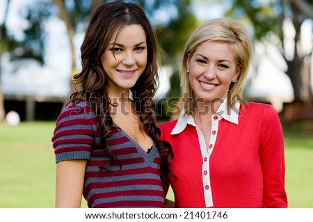 Two young attractive women standing together at college