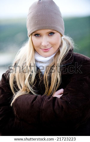 A young attractive woman outside on a beach in winter wear