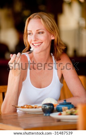 A young woman on vacation enjoying lunch at a restaurant