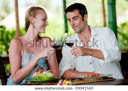 A good-looking couple having meal with wine