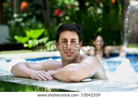 An attractive caucasian man relaxing in a jacuzzi pool outdoors