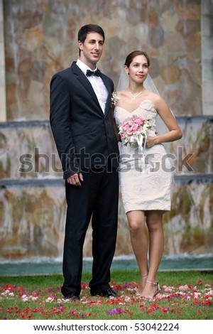 Attractive caucasian newly weds getting married outdoors at a waterfall