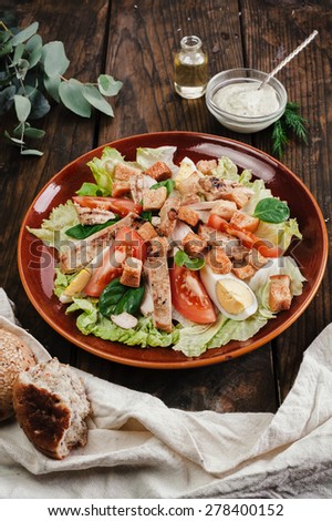 Full plate of salad in dark plate on wooden table