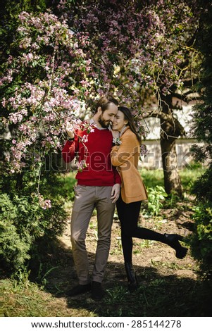 young lovely couple hipster family in flower garden park in full growth