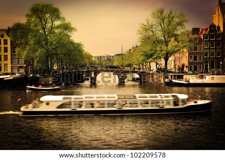 Amsterdam, Holland, Netherlands. Romantic bridge over canal, cabin cruiser. Old town