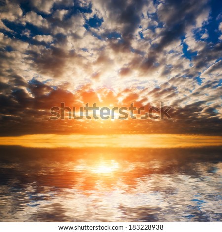 Abstract, dramatic sunset at the sea, ocean. Sun and clouds reflection in water