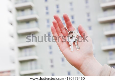 A real estate agent holding keys to a new apartment in her hands. Real estate industry