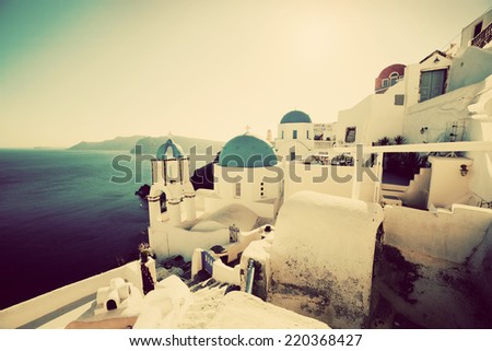 Oia town on Santorini island, Greece at sunset. Vintage, retro style. Traditional and famous churches with blue domes over the Caldera, Aegean sea