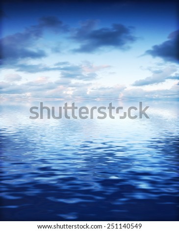Ocean with calm waves background with dramatic sky. Blue, cold tint.