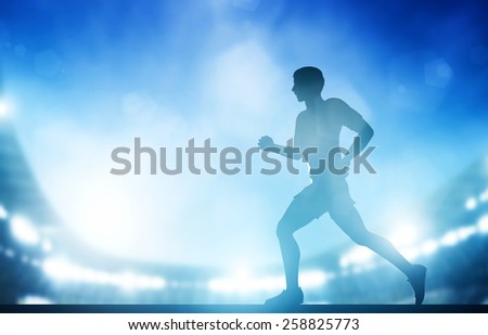 Man running on the stadium in night lights. Athletics run concept.
