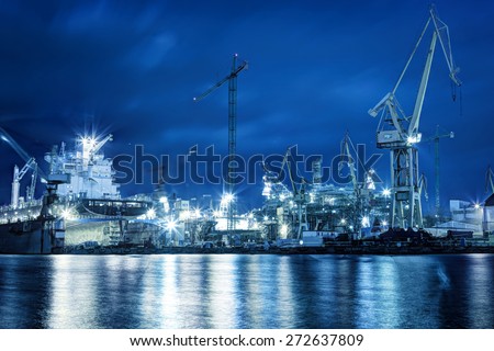 Shipyard at work, ship repair. Industrial machinery, cranes. Transport, freight concept