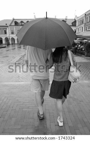 Couple with umbrella walking in rain