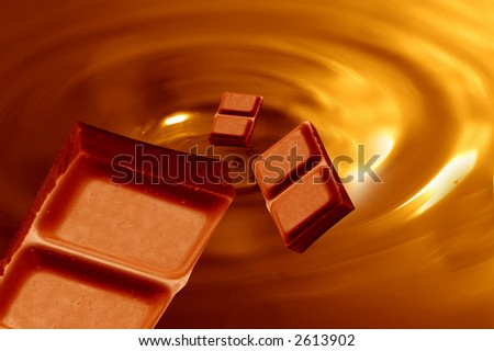 Little bars of chocolated falling into melted chocolate mass
