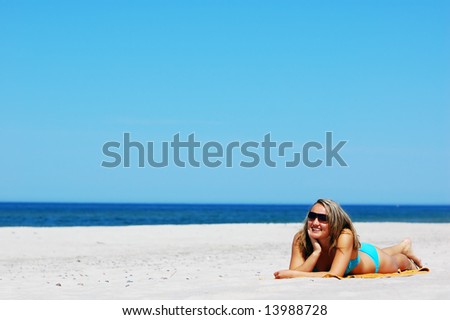Beautiful woman relaxing on the beach. Lots of useful copyspace