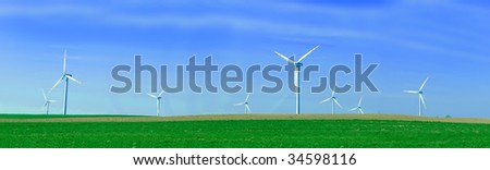 Panorama of the wind turbnes on a summer field