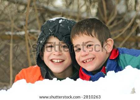 Two Boys playing outside in the Snow