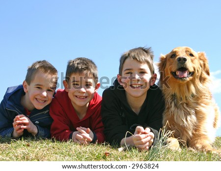 A dog smiling with three young boys