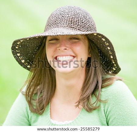 A Smiling Young Woman Wearing a Brown Hat