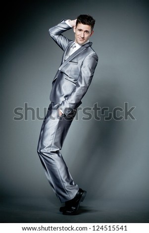 Young happy businessman in gray suit.
