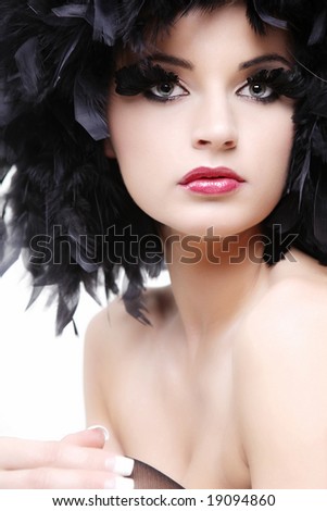 Beautiful topless young woman in black feathers on white background.