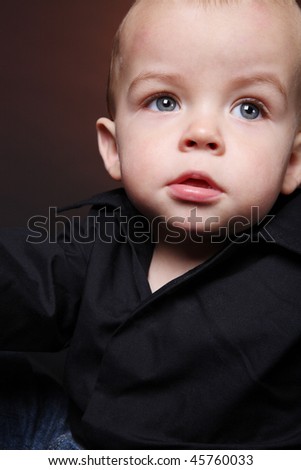 Portrait of small cute boy in black shirt.