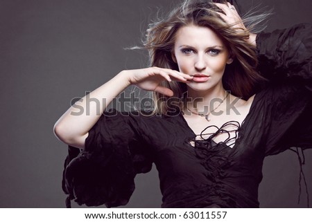 Young attractive fashion model posing on dark background.