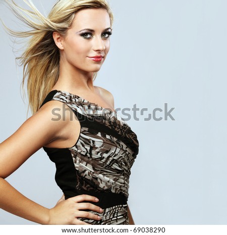 Young attractive happy fashion model witj long hair posing in studio.