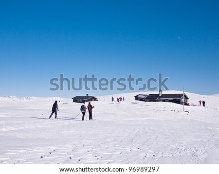 Skiers closing a meeting point with some cottages at easter in norwegian highland