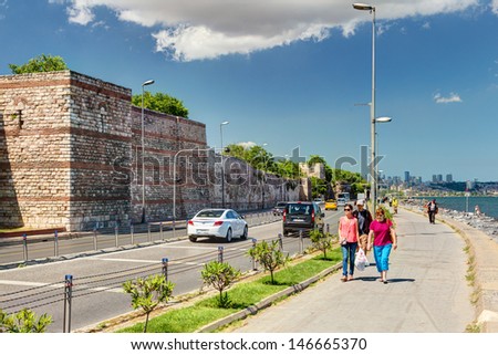 ISTANBUL - MAY 27: People walk along the promenade past the sea walls of Constantinople on May 27, 2013 in Istanbul, Turkey. In ancient Constantinople had the most powerful fortifications in the world