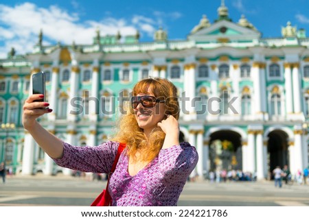 Selfie of a young female tourist on the background of the Winter Palace in Saint Petersburg, Russia