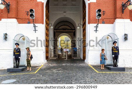MOSCOW - JULY 10, 2015: Tourists pose for a photo next to the guard of honor at the entrance to the Kremlin. The gate of the Spasskaya tower.